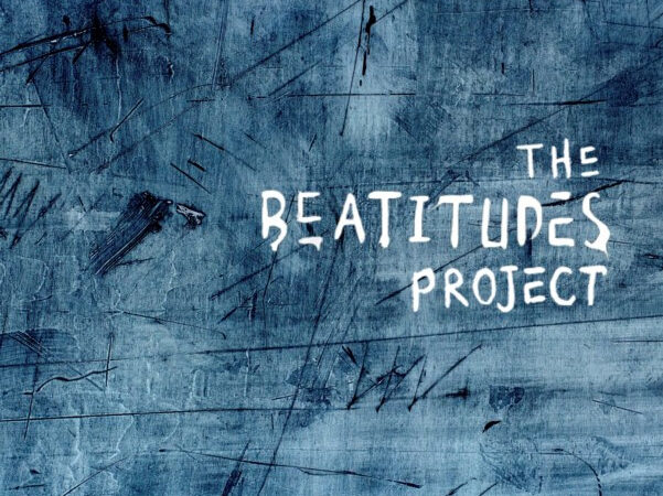 Blue textured background with white text saying The Beatitudes Project. Abstract design with scratches.
