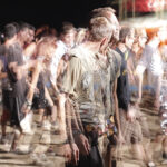 Blurred crowd at a nighttime outdoor music festival, creating a sense of movement and energy.