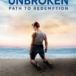Man kneeling on beach with sunset, Unbroken: Path to Redemption movie poster showcasing resilience and hope.