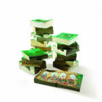 Stacks of green-covered comic books on a white background, with an open book displaying colorful illustrations.