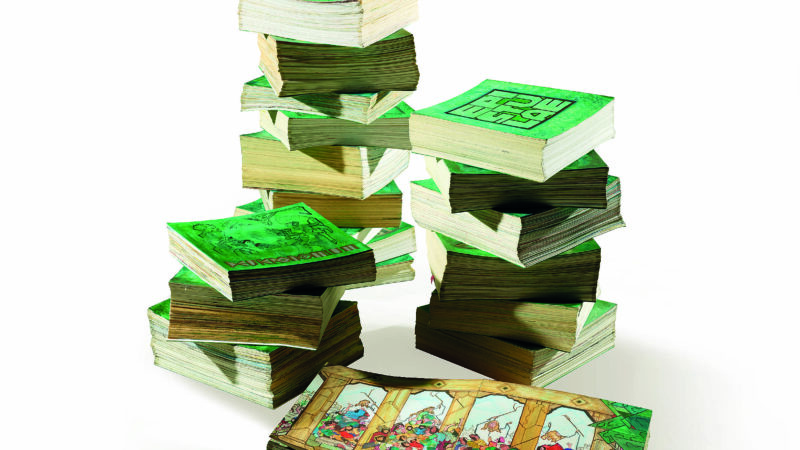 Stacks of green-covered comic books on a white background, with an open book displaying colorful illustrations.