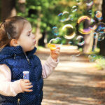 child blowing bubbles