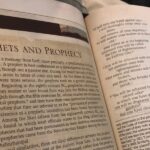 Open Bible showing text on prophets and prophecy from Isaiah 1, discussing biblical themes and interpretations.