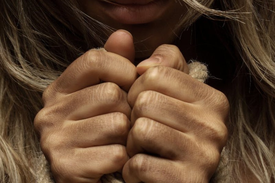 Close-up of hands clenching around a rope, suggesting strength and resilience.