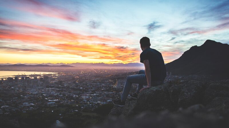 Man on hill viewing city