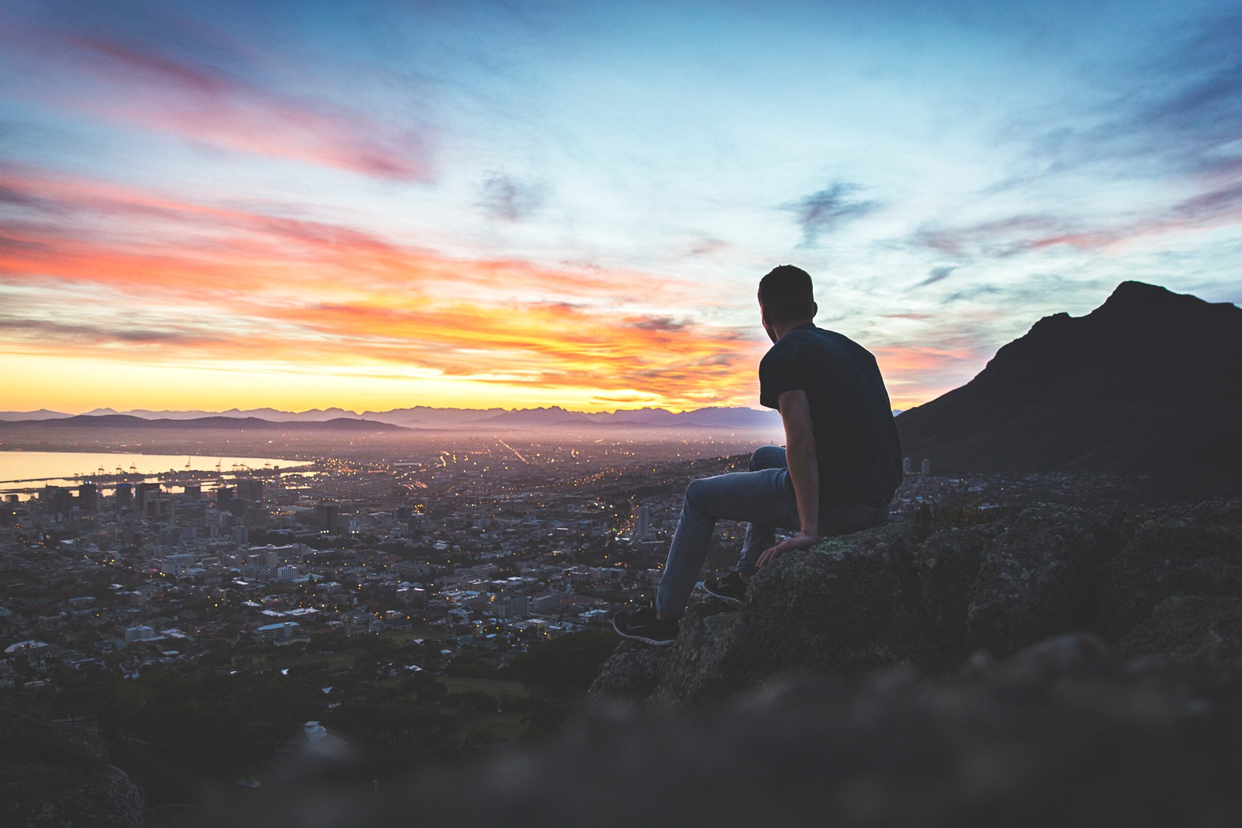 Man on hill viewing city