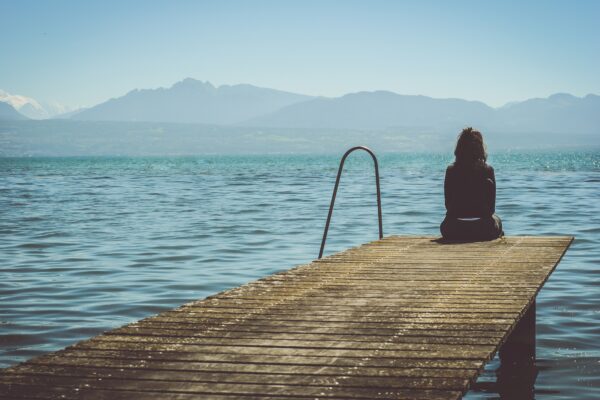 person sitting on end of pier