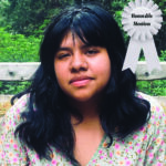 Young person outdoors with a floral top and an Honorable Mention ribbon.