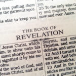 Open Bible page showing heading for the Book of Revelation with text references to Jesus Christ.
