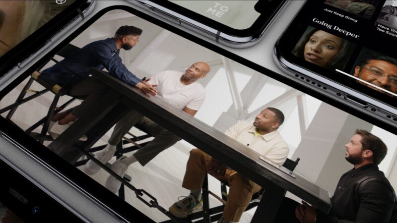 Group discussion at a table displayed on multiple smartphones, showcasing digital content streaming.