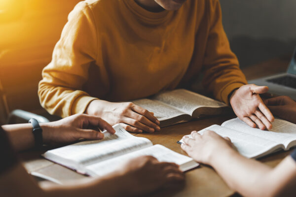 Christian couple or group reading study the bible together and pray at a home or Sunday school at church. concept studying the word of god.