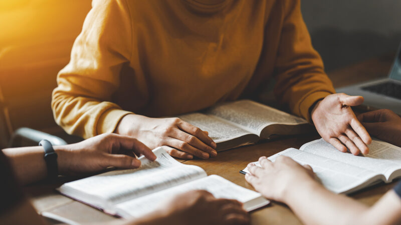 Christian couple or group reading study the bible together and pray at a home or Sunday school at church. concept studying the word of god.