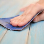 Process of hand polishing wooden board surface with a sandpaper
