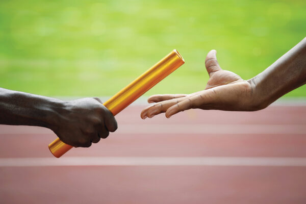 Two men passing golden baton in stadium