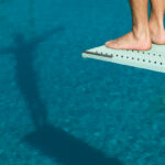 Male swimmer standing on diving board